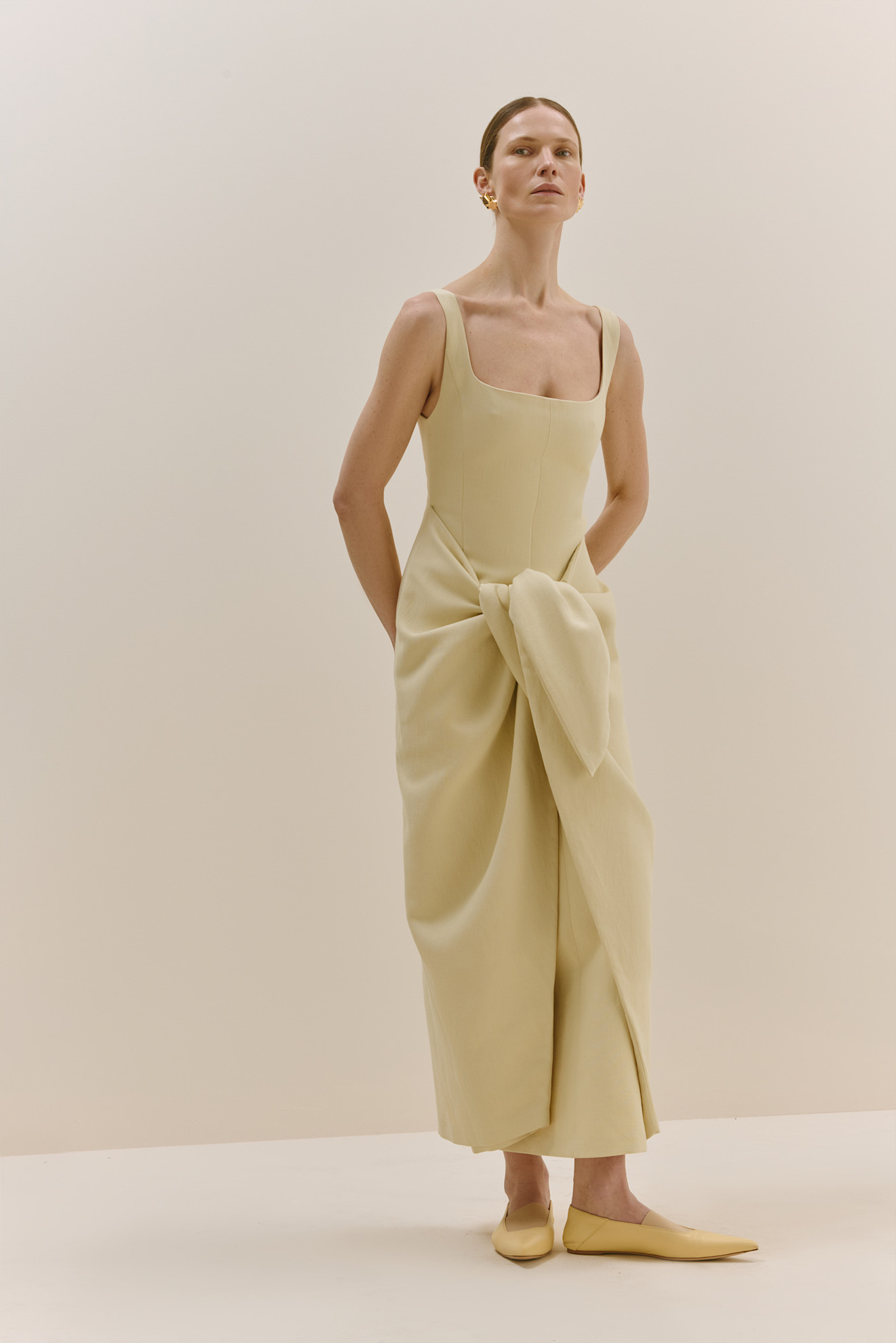 Нежно-желтое платье с квадратным вырезом и объемным бантом, придающее образу игривость и стиль
