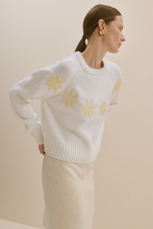 Белый свитер с объемными звездами из кожи, сочетание текстур с облегающей юбкой в нейтральных тонах