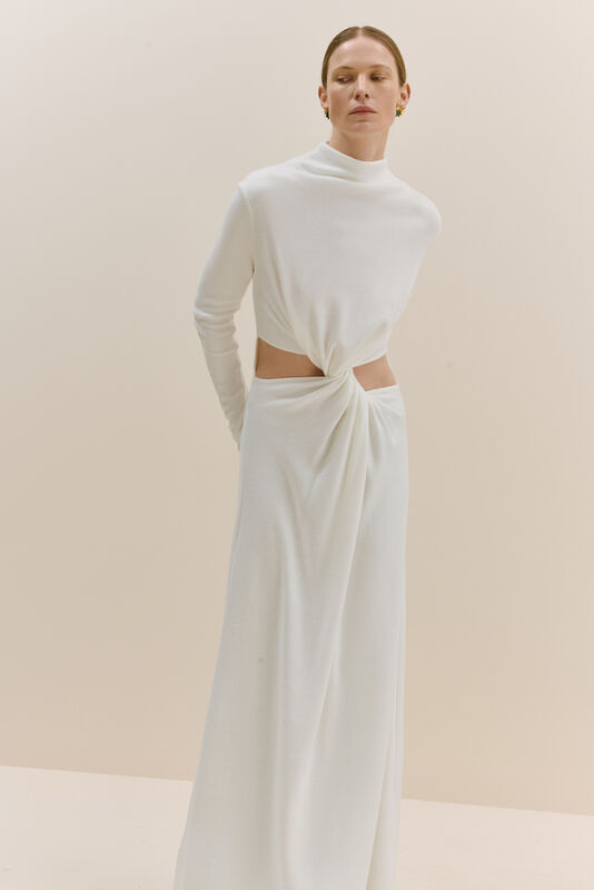 Элегантное белое платье с высоким воротником и открытой талией, создающее эффект струящейся ткани
