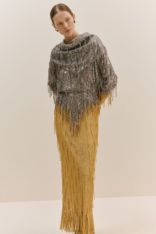 Блестящий топ с бахромой из серебристых пайеток, дополненный золотой юбкой, создаёт эффектный контраст текстур и цветов