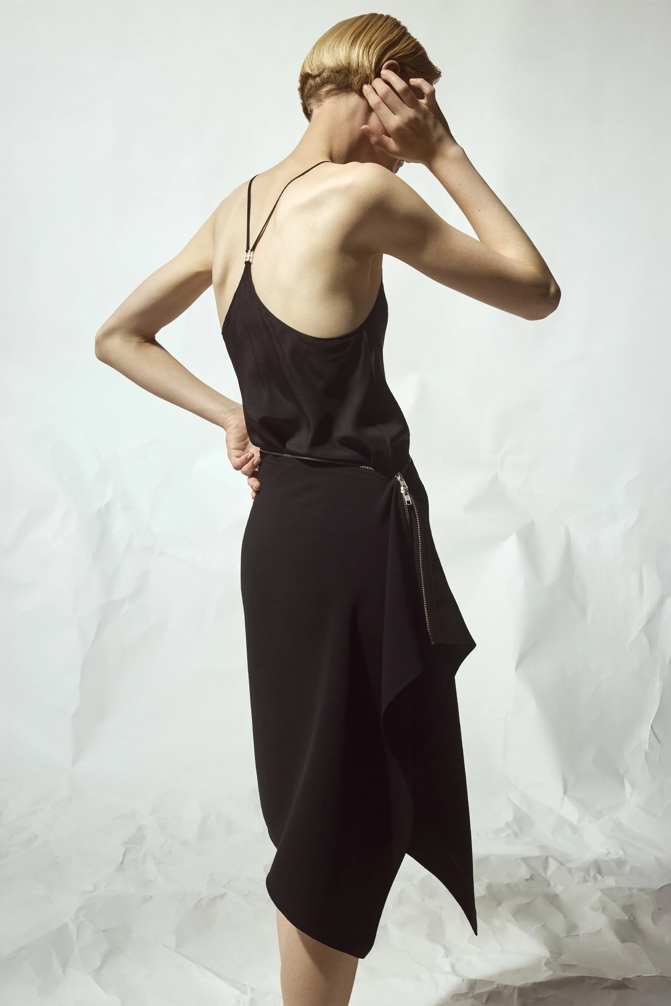 Элегантный черный комплект с тонкими бретелями и асимметричным подолом, акцентирующий внимание на линии талии