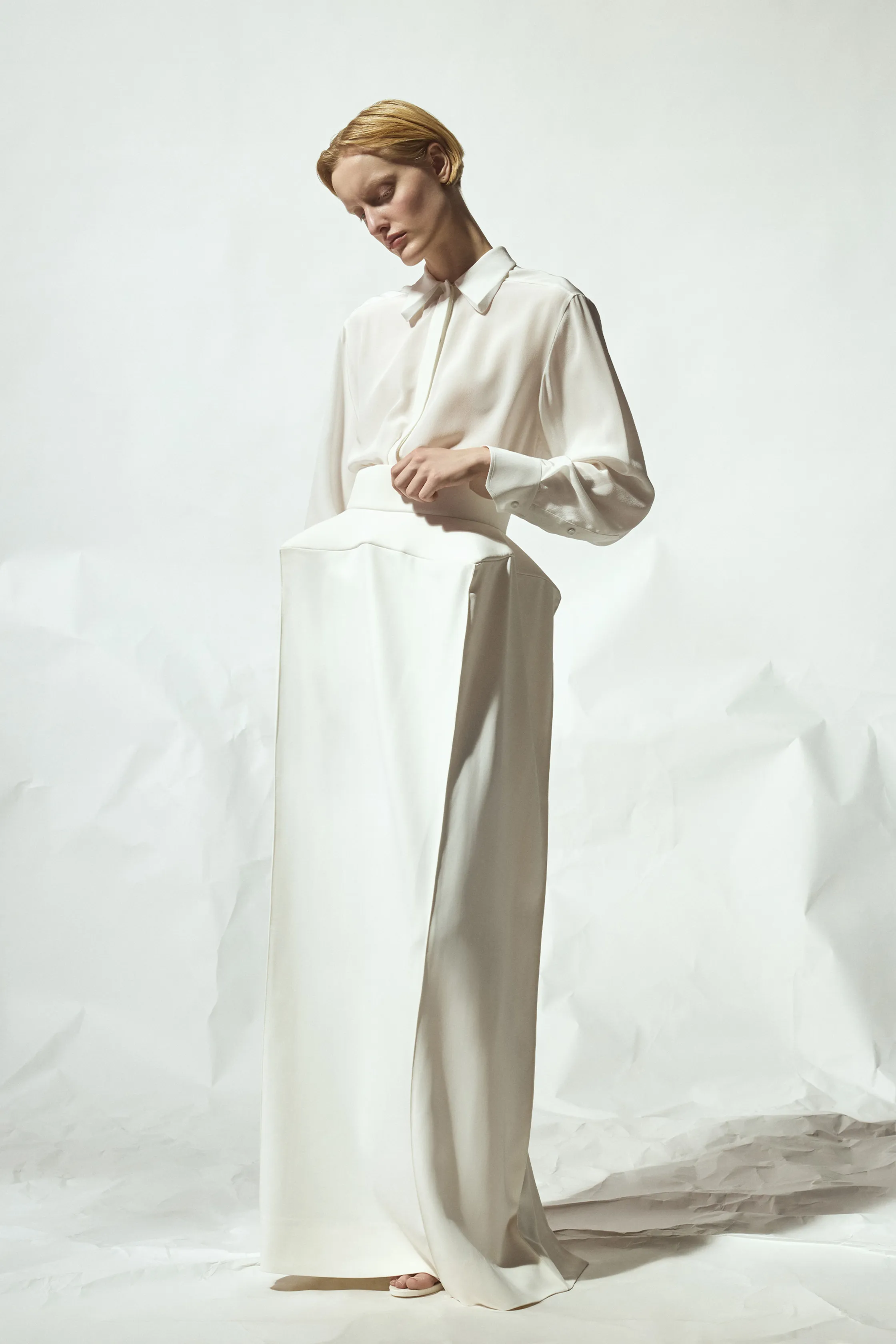 Нежное белое платье с прозрачной блузкой и строгими линиями, подчеркивающее утонченность силуэта