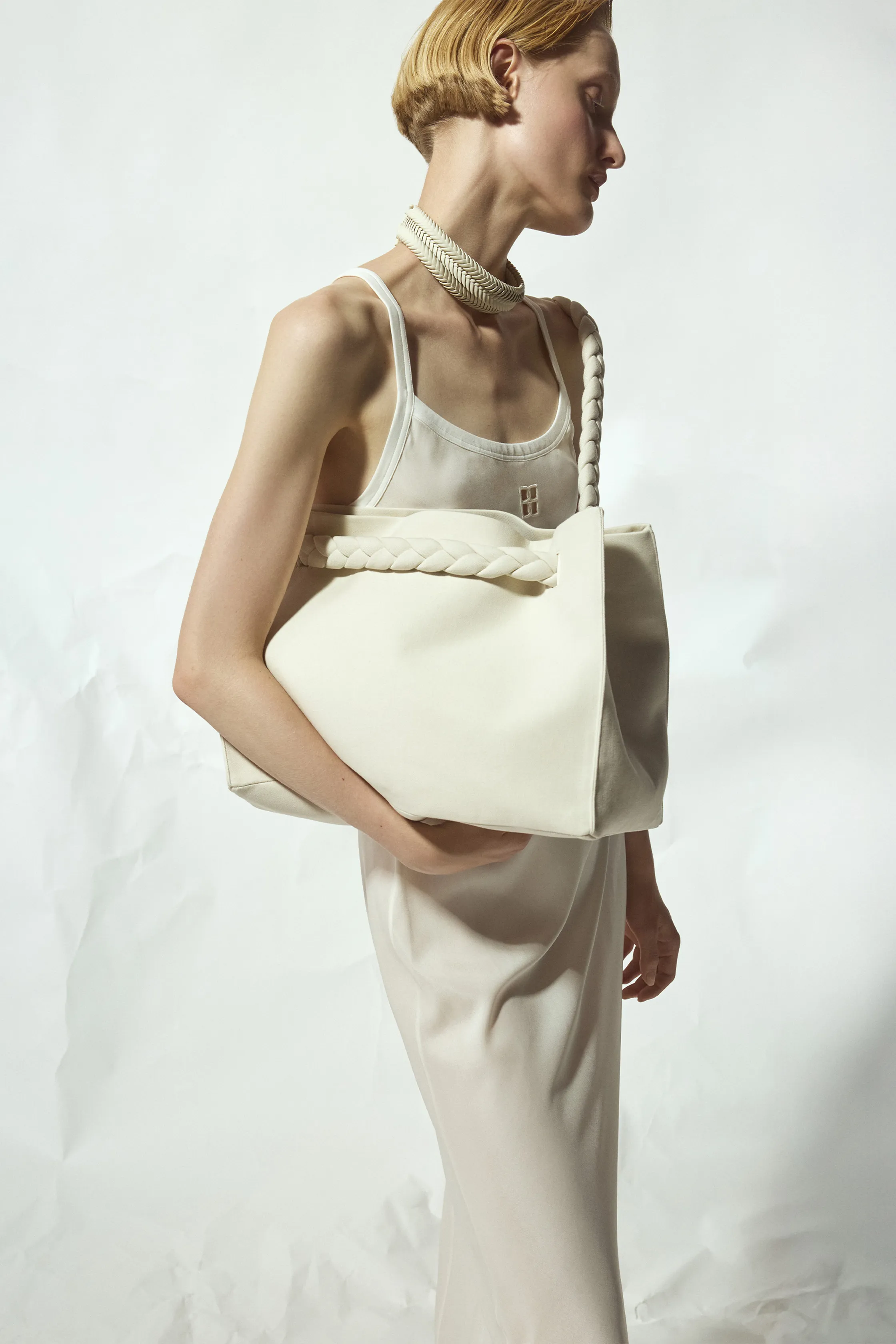 Стильный образ с белой сумкой и облегающим платьем, акцент на текстуре и минимализме аксессуаров