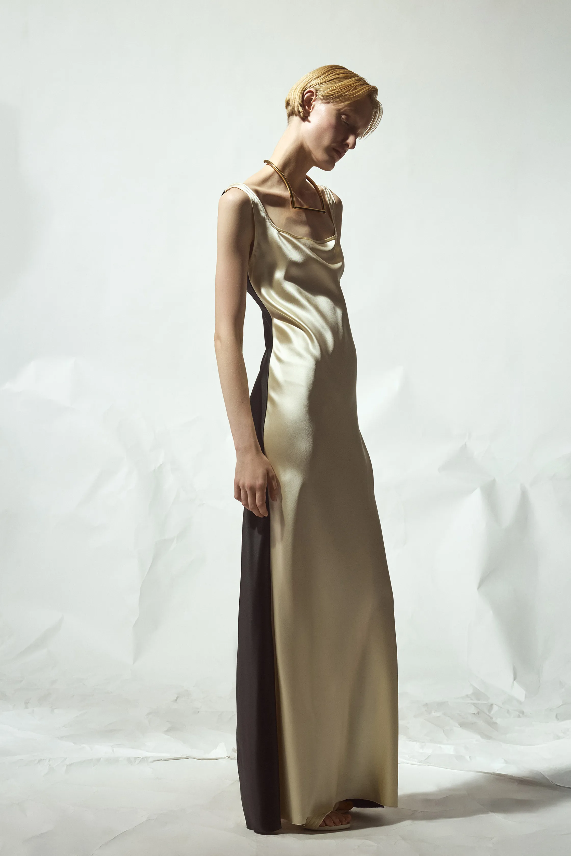 Платье из блестящего сатина с глубоким вырезом и контрастными черными вставками, излучающее утонченность