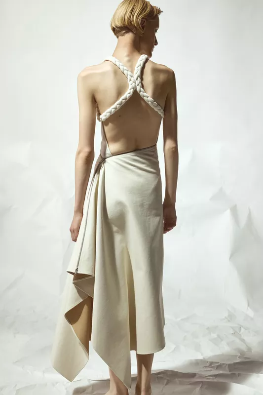 Открытое платье с плетеными бретелями и завязкой на талии, создающее эффект легкости и романтики