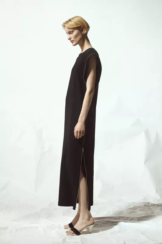 Простое черное платье с длинными боковыми разрезами и минималистичным дизайном, подчеркивающее утонченность и стиль модели
