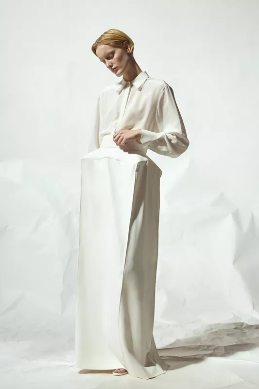 Нежное белое платье с прозрачной блузкой и строгими линиями, подчеркивающее утонченность силуэта