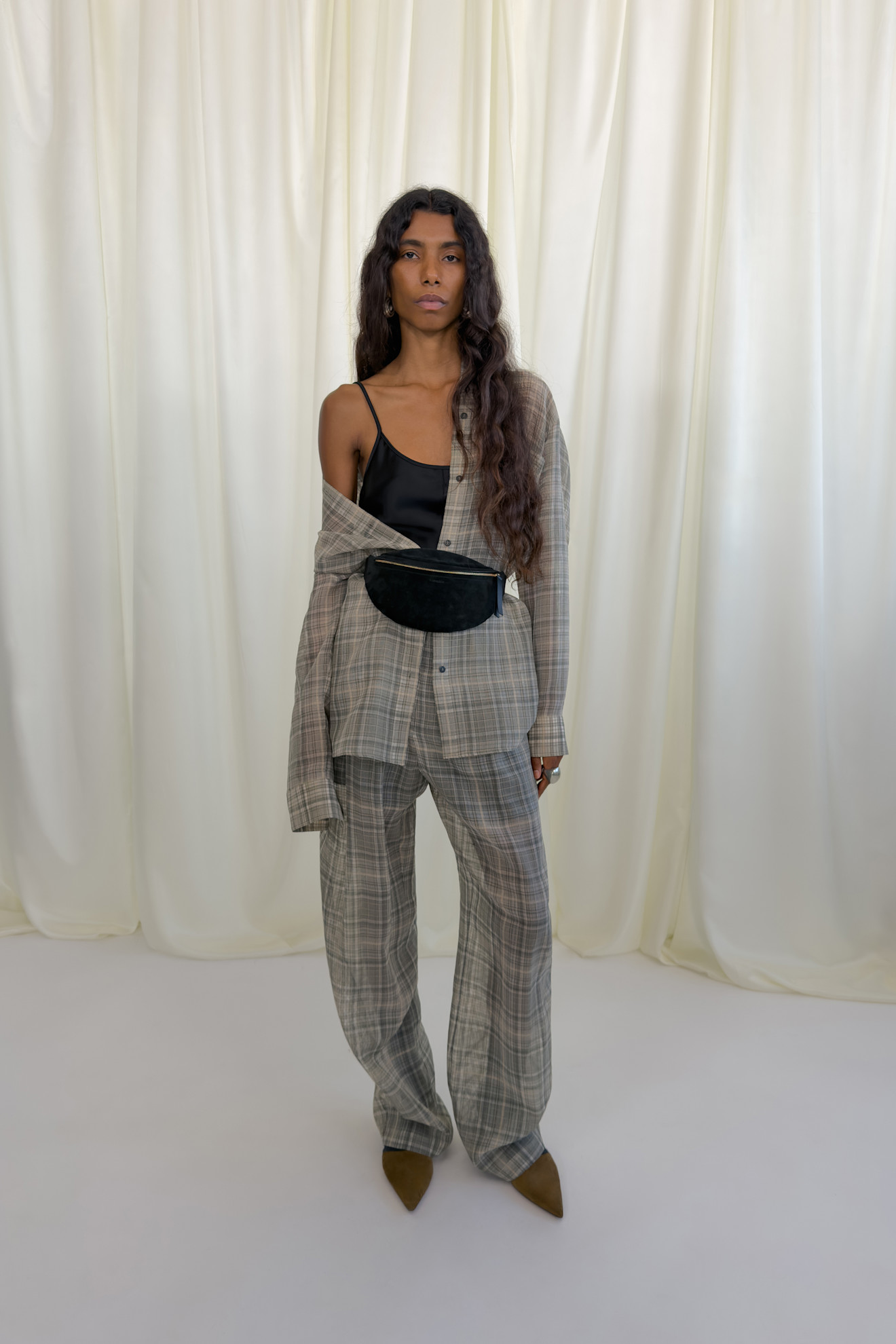 Элегантный комплект в клетку с широкими брюками и открытым плечом, дополненный черной сумкой на талии