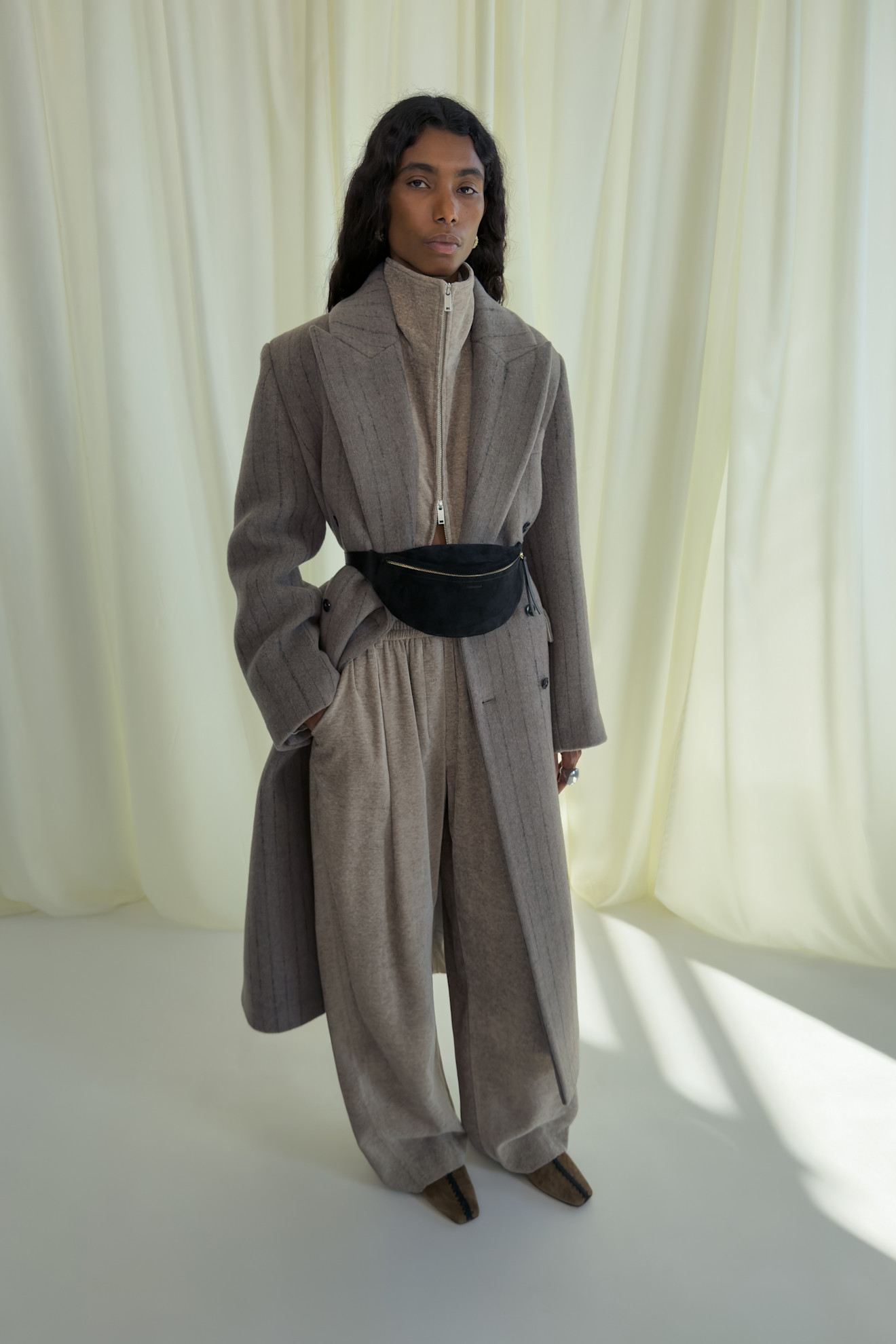 Стильный ансамбль с пиджаком в полоску и широкими брюками, дополненный поясной сумкой для акцента