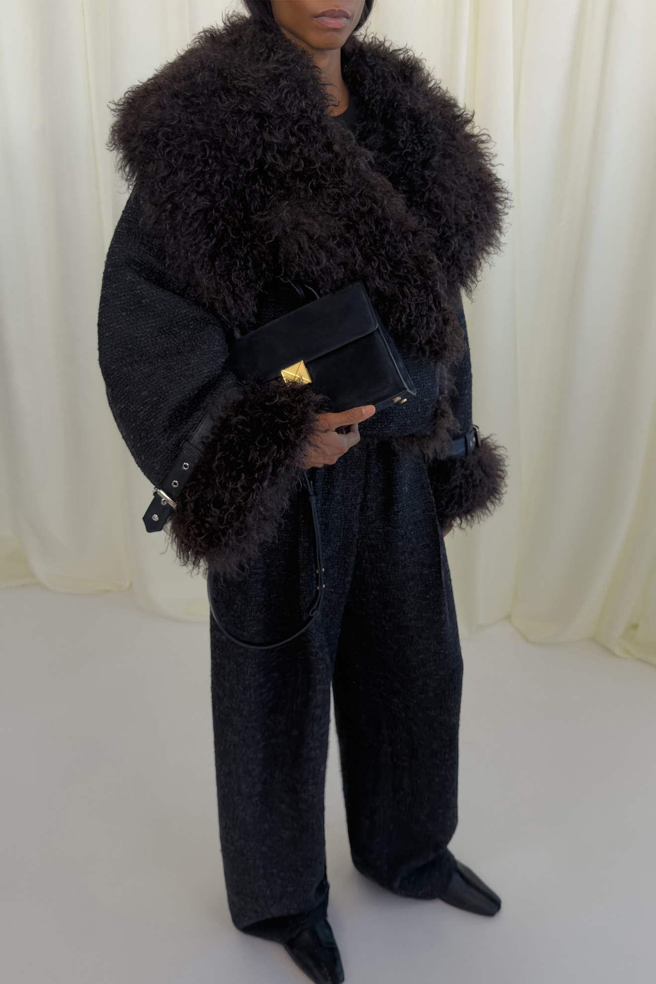 Шершавая черная куртка с объемным воротником и стильная сумка с золотистой фурнитурой для элегантного образа
