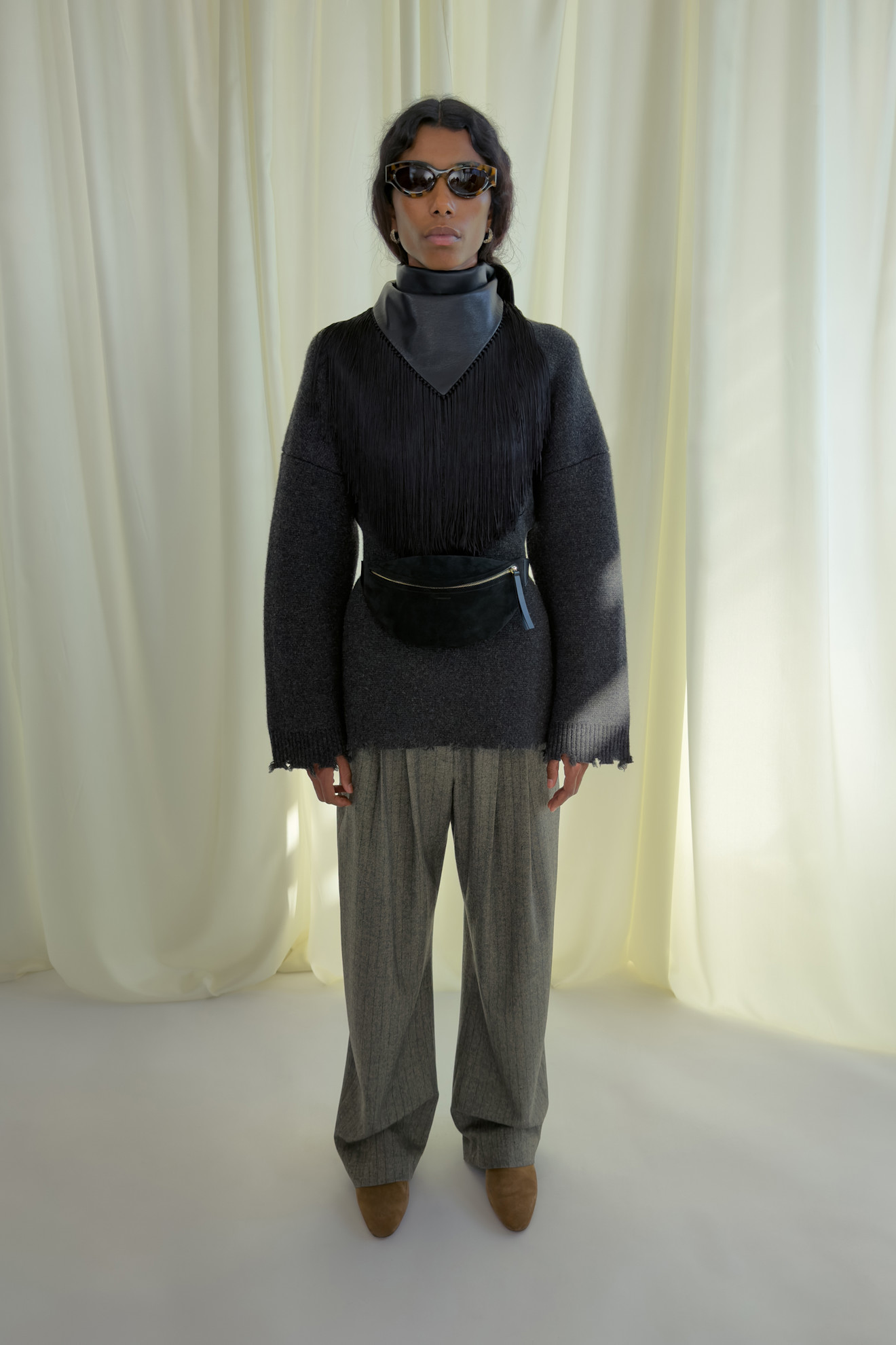 Серый свитер с бахромой и широкие брюки в сочетании с поясной сумкой для современного и стильного образа