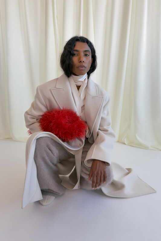 Элегантный светлый плащ с красным аксессуаром из меха, дополненный мягкими серыми брюками и белым шарфом