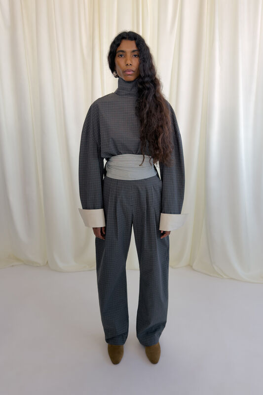 Стильный комплект в клетку с объемным верхом и широкими брюками, акцент на контрастные манжеты и пояс