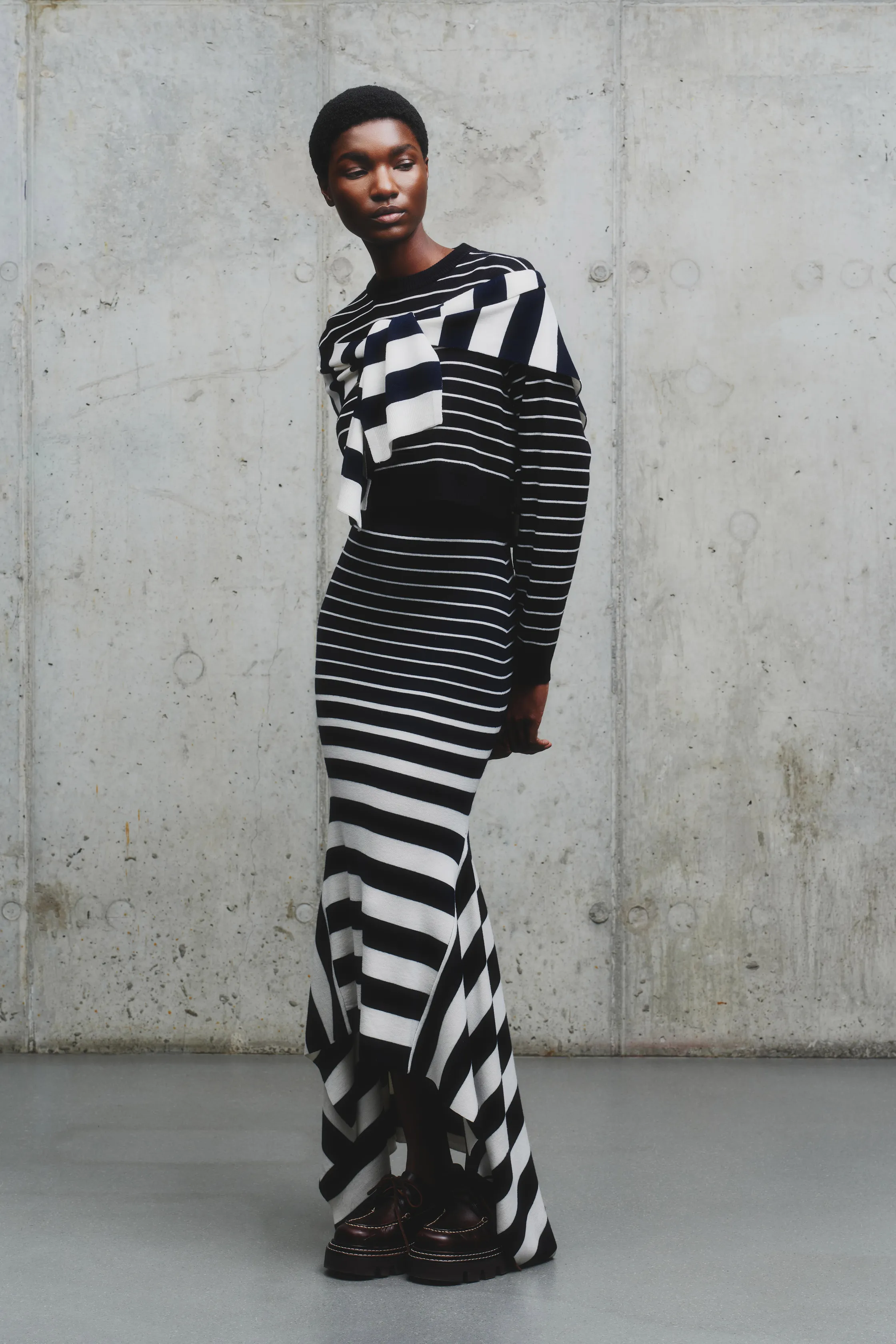 Строгий черно-белый наряд с асимметричным подолом и объемным верхом, создающий эффект динамики и элегантности