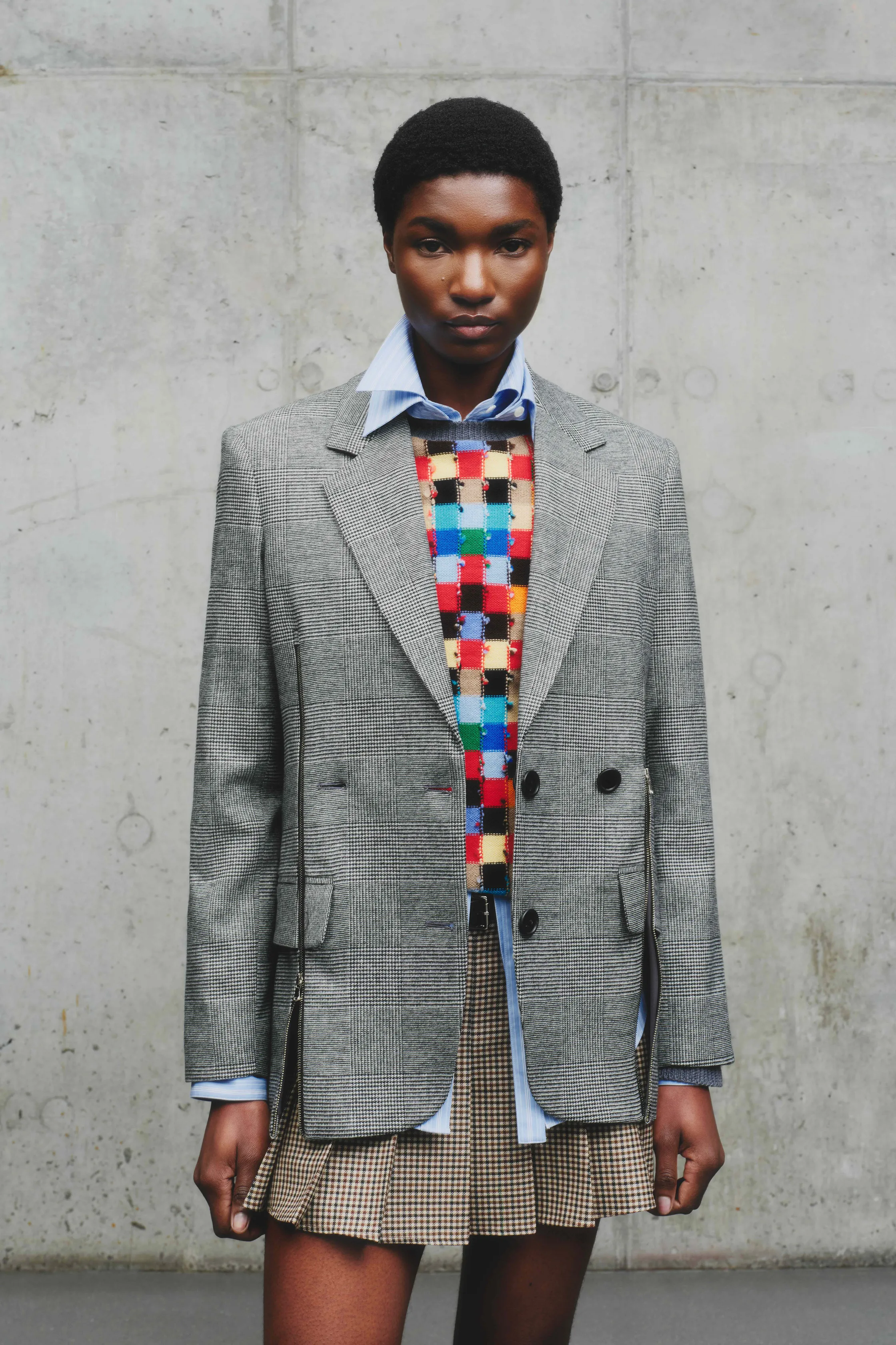 Элегантный пиджак в клетку с ярким свитером и мини-юбкой, сочетание формального и кэжуал стилей для смелого образа