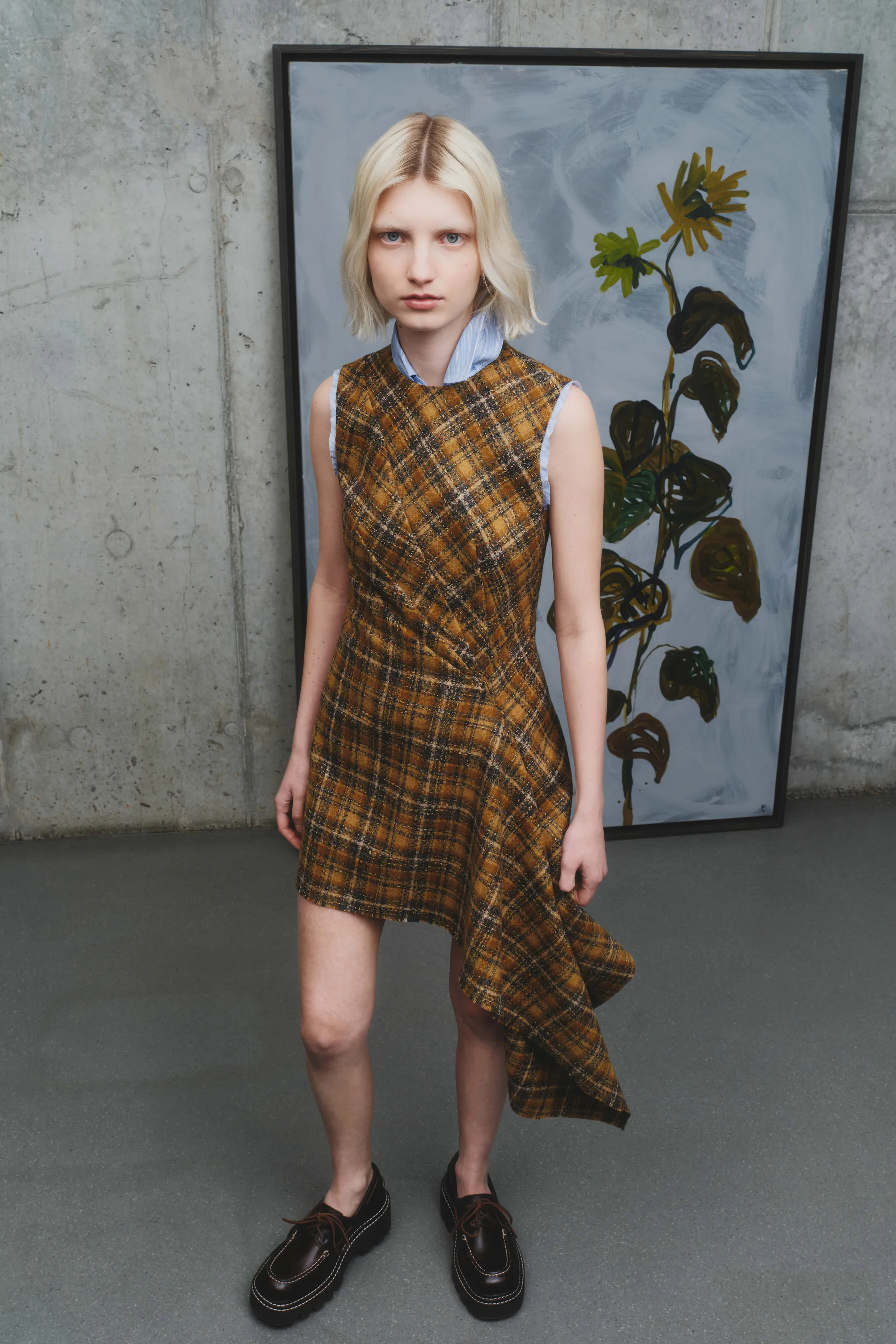 Платье с асимметричным подолом в клетку, теплые коричневые оттенки, сочетание с голубой рубашкой, создающее стильный контраст