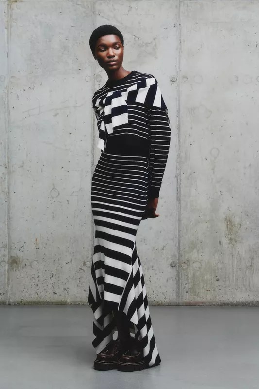 Строгий черно-белый наряд с асимметричным подолом и объемным верхом, создающий эффект динамики и элегантности