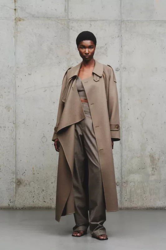 Элегантный образ в бежевом пальто и клетчатом костюме, акцент на текстуре тканей, минималистичный стиль с открытым животом