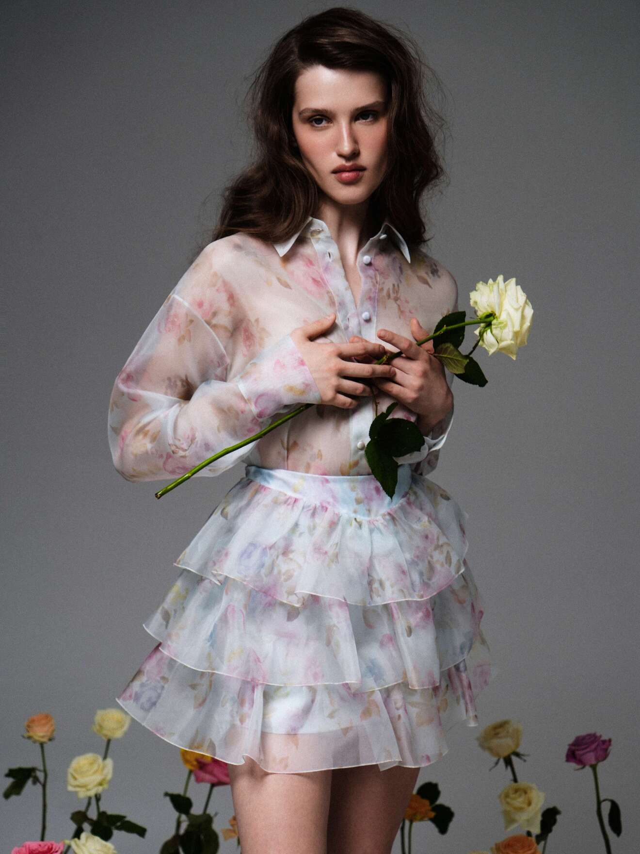 Прозрачная блуза с цветочным узором и короткая юбка, подчеркивающие легкость и свежесть весеннего образа