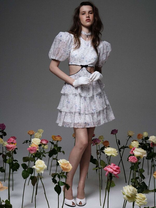 Легкое белое платье с объемными рукавами и открытыми боками, дополненное перчатками и цветами вокруг