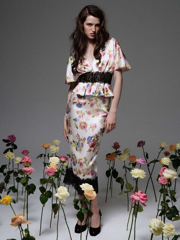 Платье с пышными рукавами и черной отделкой, акцент на цветах и контрасте, создающее эффектный образ для весны