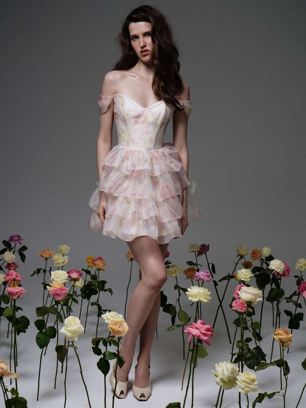 Нежное платье с рюшами в пастельных тонах, окруженное цветущими розами, создает романтичную весеннюю атмосферу.