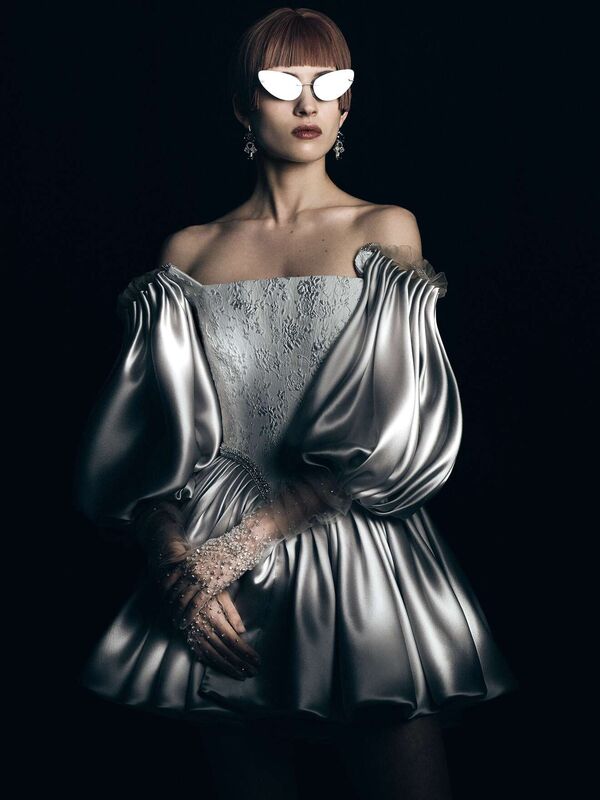 Платье с объемными рукавами и блестящей юбкой, украшенное кружевом, дополненное стильными очками и изысканными серьгами