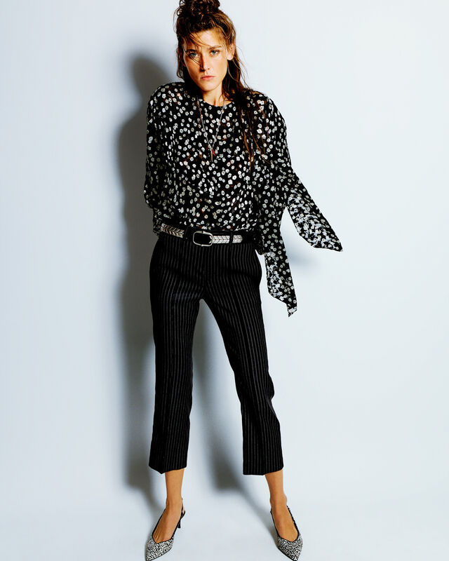 Полупрозрачная блуза с цветочным принтом и полосатые брюки, завершающие образ с изысканными туфлями на каблуке