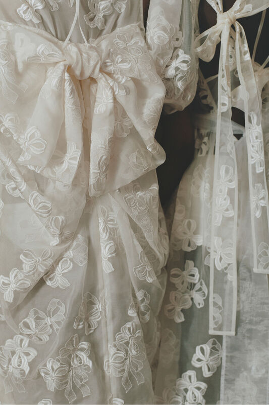 Элегантные платья с объемными белыми бантами и цветочной вышивкой, подчеркивающие утонченность и легкость образа