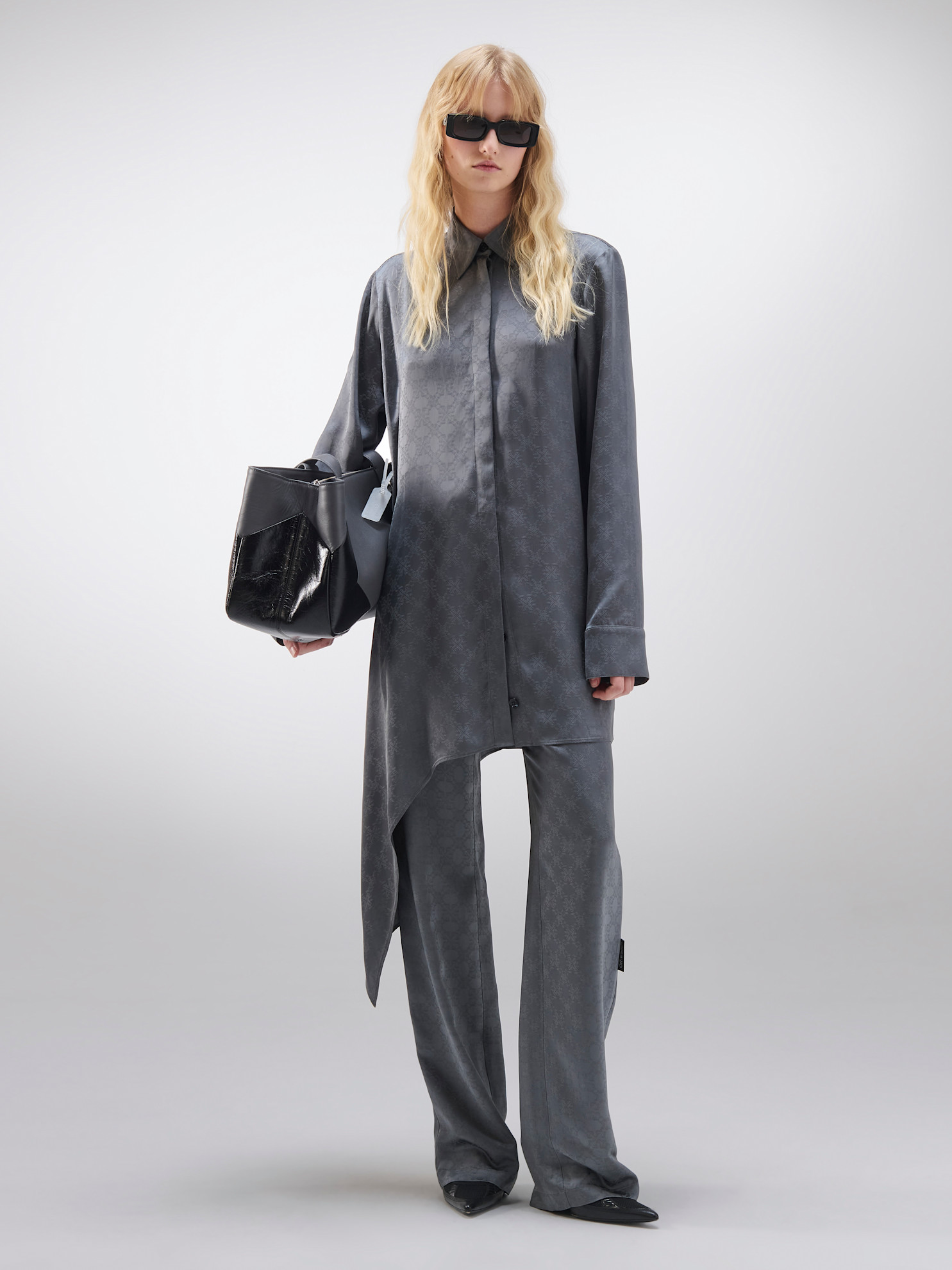 Серый комплект из шелковистой ткани с асимметричным кроем и стильными солнцезащитными очками подчеркивает элегантность