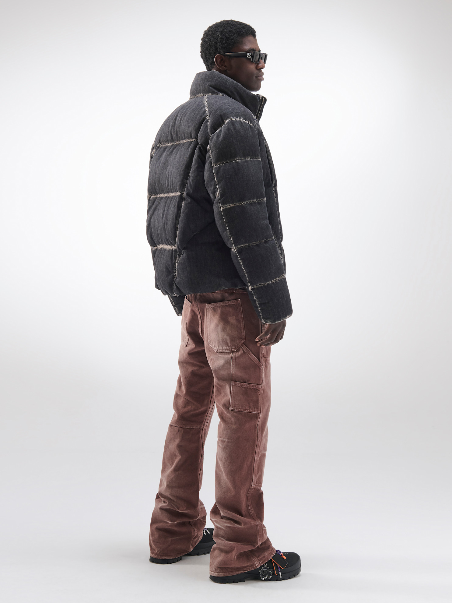 Утепленная куртка с контрастными швами и коричневыми брюками, создающая современный образ с акцентом на текстуру