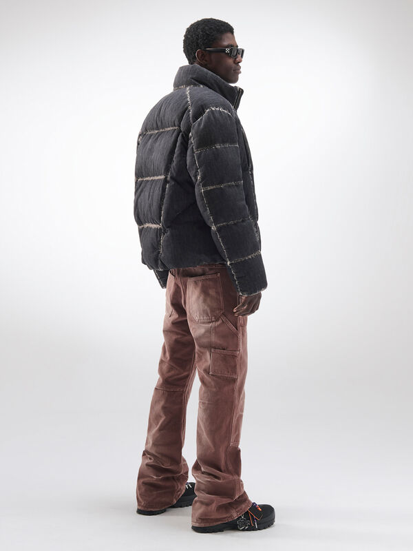 Утепленная куртка с контрастными швами и коричневыми брюками, создающая современный образ с акцентом на текстуру