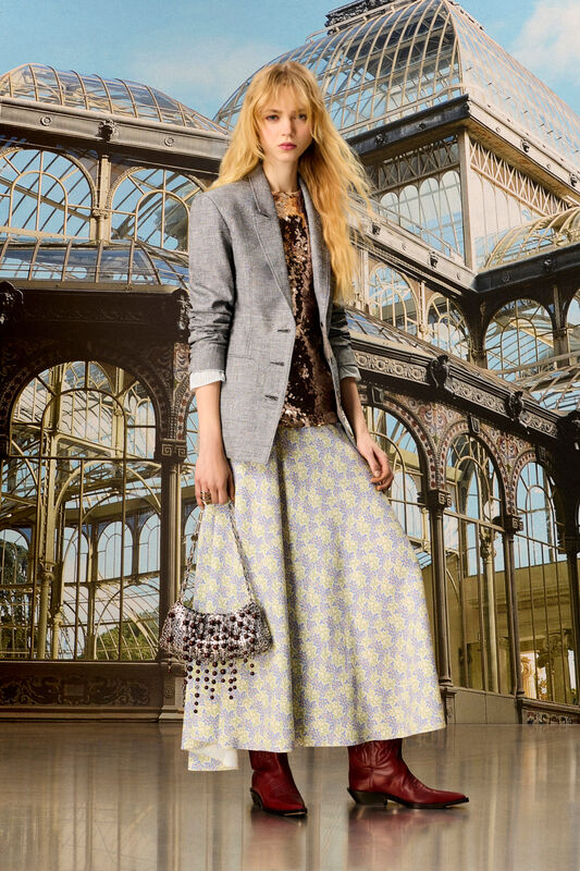 Элегантный образ с серым пиджаком и блестящей юбкой, дополненный бордовыми сапогами и стильной сумкой