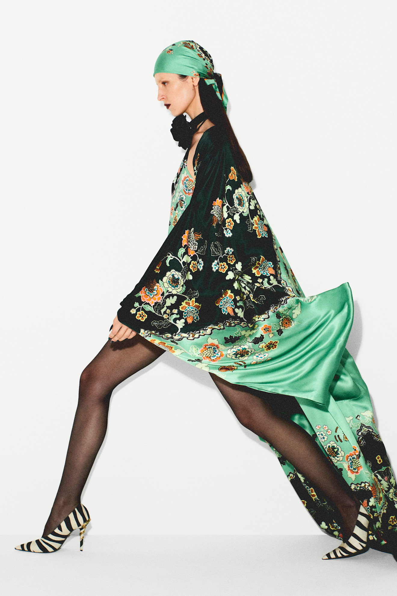 Платье с цветочным принтом и длинными рукавами, эффектно развевающееся на фоне, завершенное туфлями в полоску