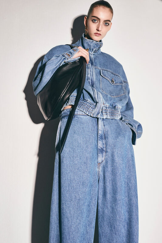 Объемный джинсовый комплект с укороченной курткой и широкими брюками, дополненный черной сумкой