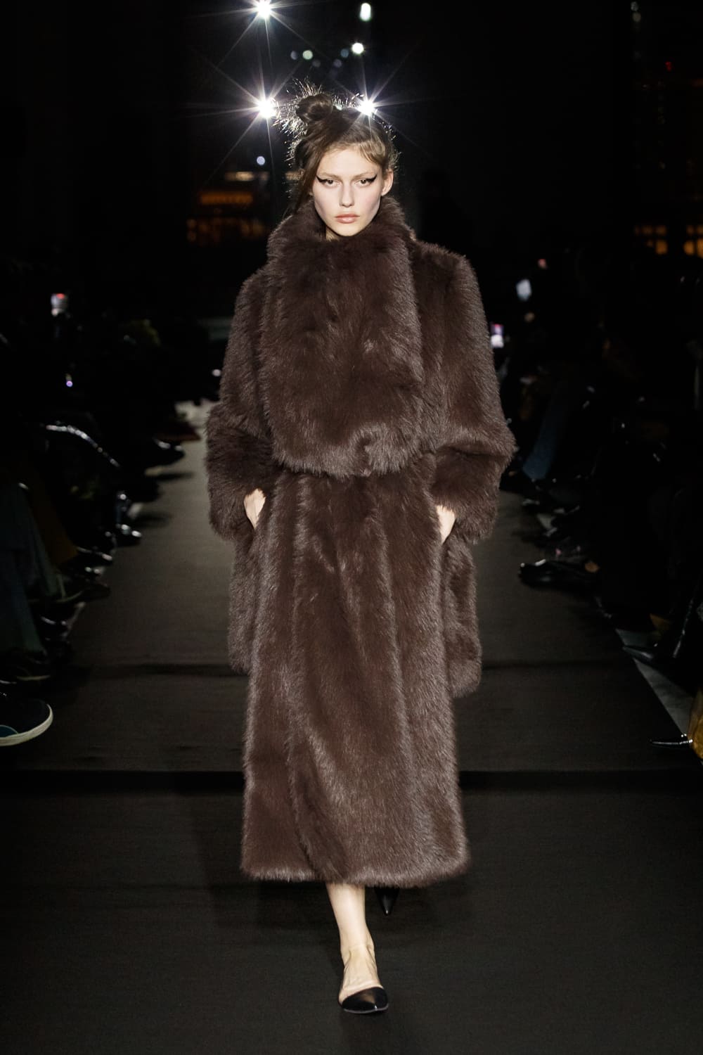 Роскошный коричневый меховой плащ с объемным воротником, создающий атмосферу уюта и стиля в зимнем показе
