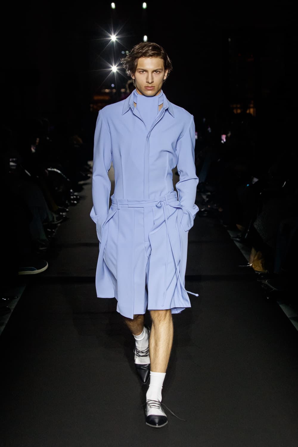 Нежное небесно-голубое пальто с поясом, элегантно обрамляющее фигуру, создает атмосферу утонченности на подиуме