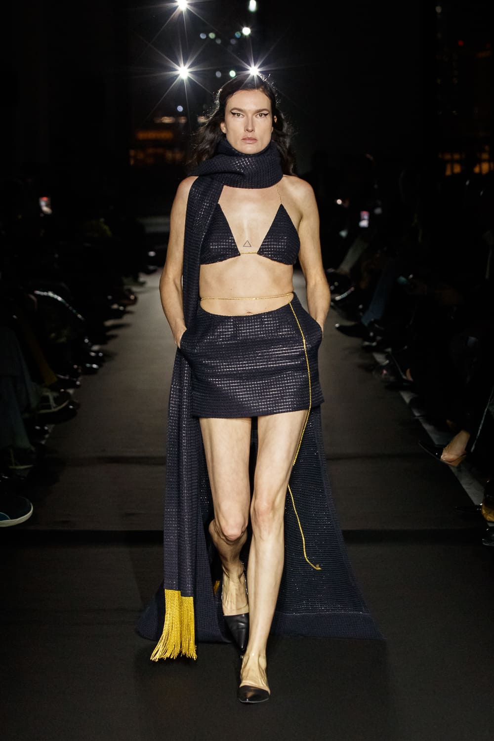 Мини-юбка и топ в темно-синем цвете с золотыми акцентами, обрамленный объемным шарфом, создают эффектный образ для осени.