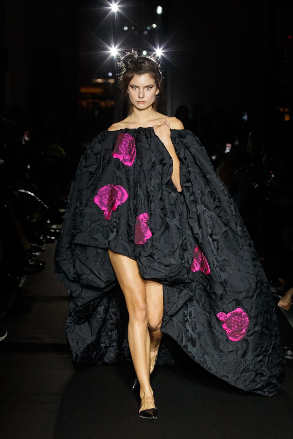 Впечатляющее черное платье с цветами, обрамляющее фигуру и создающее эффект легкости и воздушности на подиуме