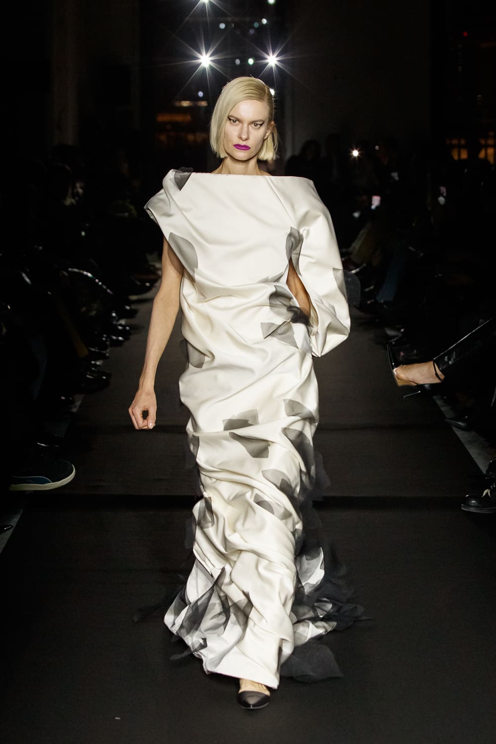 Элегантное платье с асимметричным кроем и плавными линиями, дополненное графичными черными акцентами, излучает современность