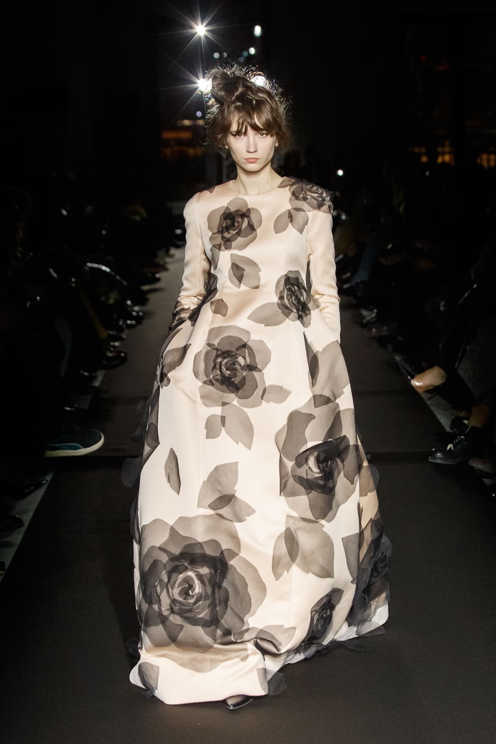 Роскошное платье с длинными рукавами и объемной юбкой, покрытой черными цветами, создает романтичный и загадочный образ