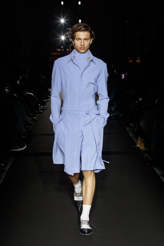 Нежное небесно-голубое пальто с поясом, элегантно обрамляющее фигуру, создает атмосферу утонченности на подиуме