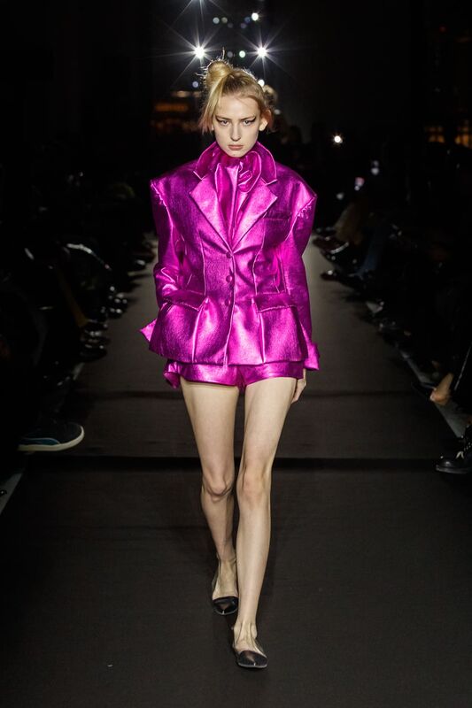 Яркий розовый костюм с блестящей текстурой и объемными рукавами, подчеркивающий смелость и индивидуальность