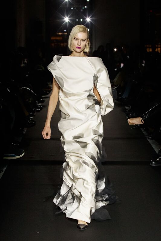 Элегантное платье с асимметричным кроем и плавными линиями, дополненное графичными черными акцентами, излучает современность