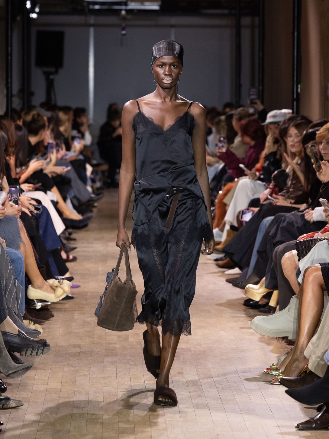 Элегантное черное платье с кружевом, дополненное сумкой, создает атмосферу утонченности на показе Ruban.