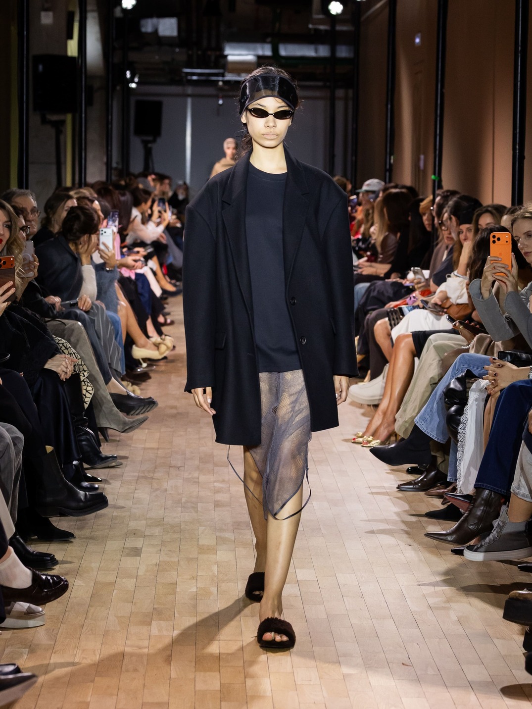 Строгий черный жакет и полупрозрачная юбка в сочетании с солнцезащитными очками создают загадочный и современный образ