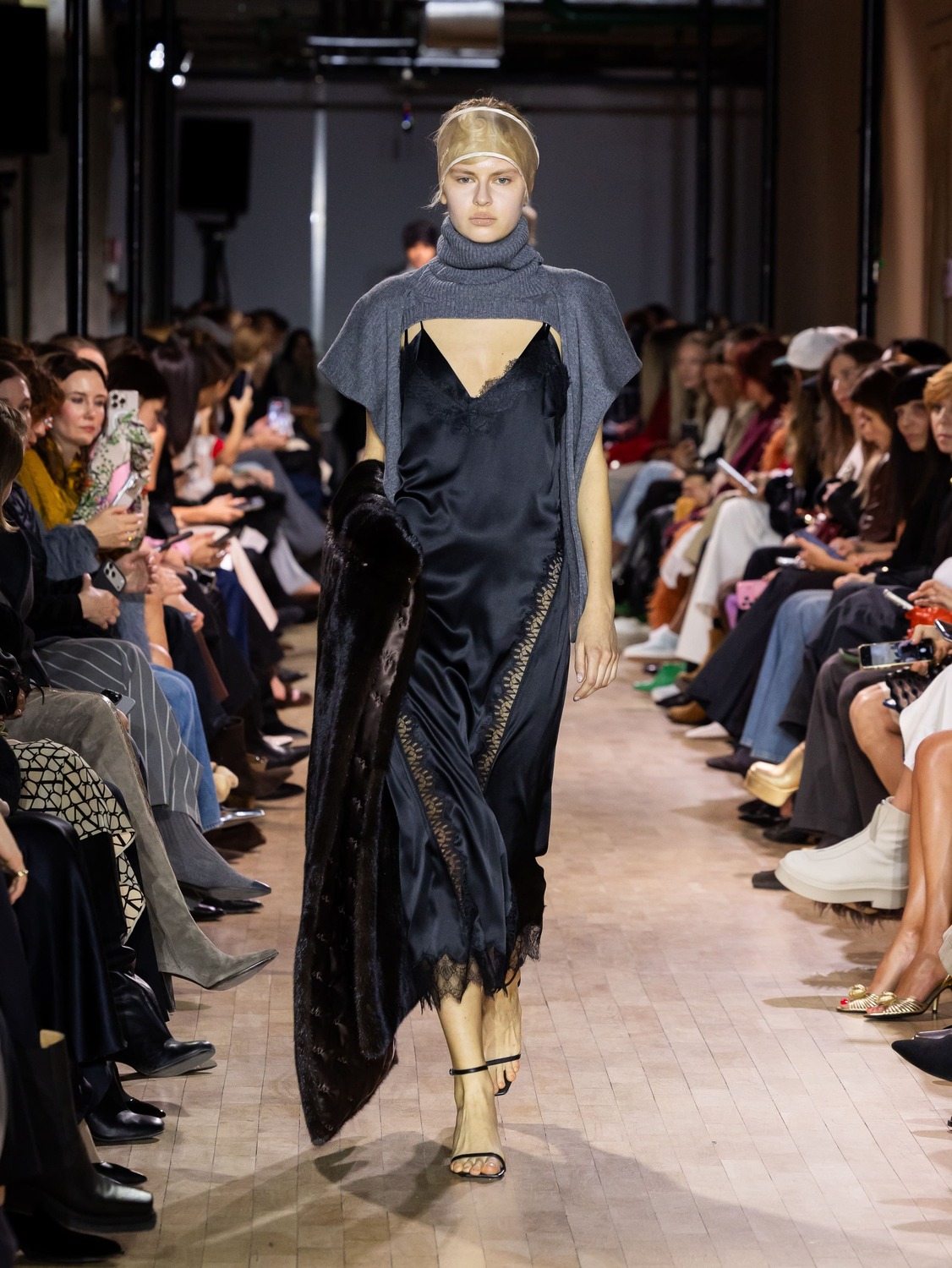 Элегантное черное платье с кружевной отделкой, дополненное серым свитером и меховым палантином, создает атмосферу утонченности