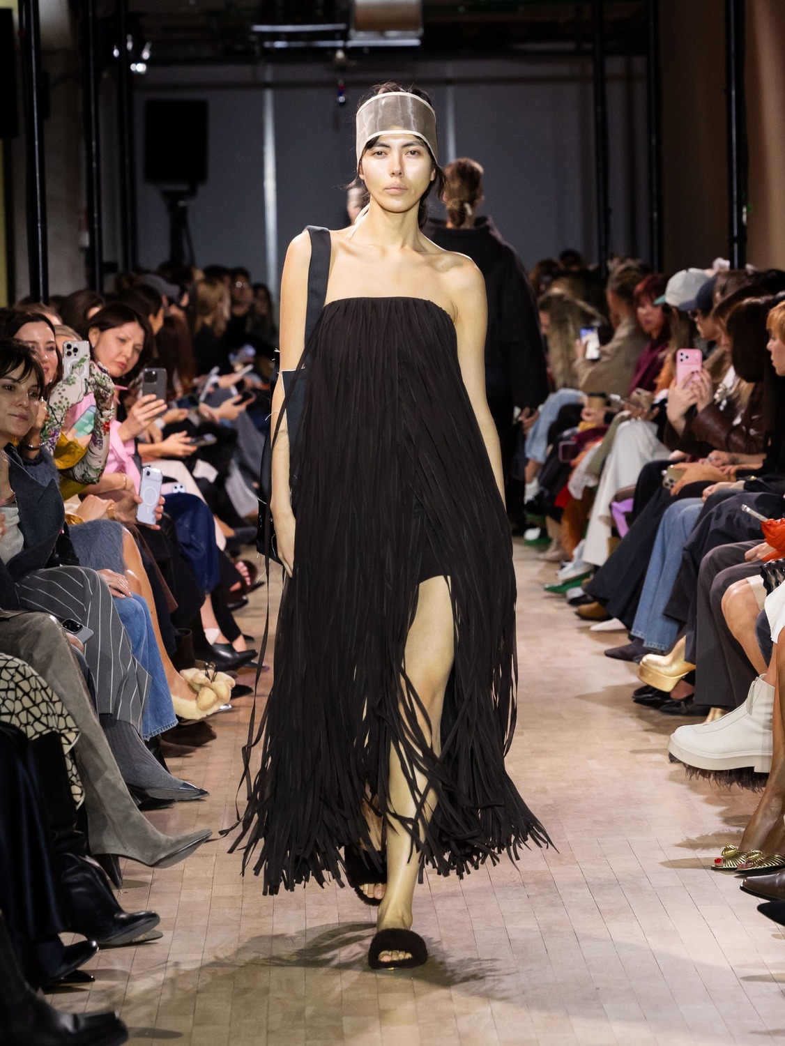 Элегантное черное платье с бахромой, открывающее ноги, подчеркивающее силуэт, с акцентом на минимализм