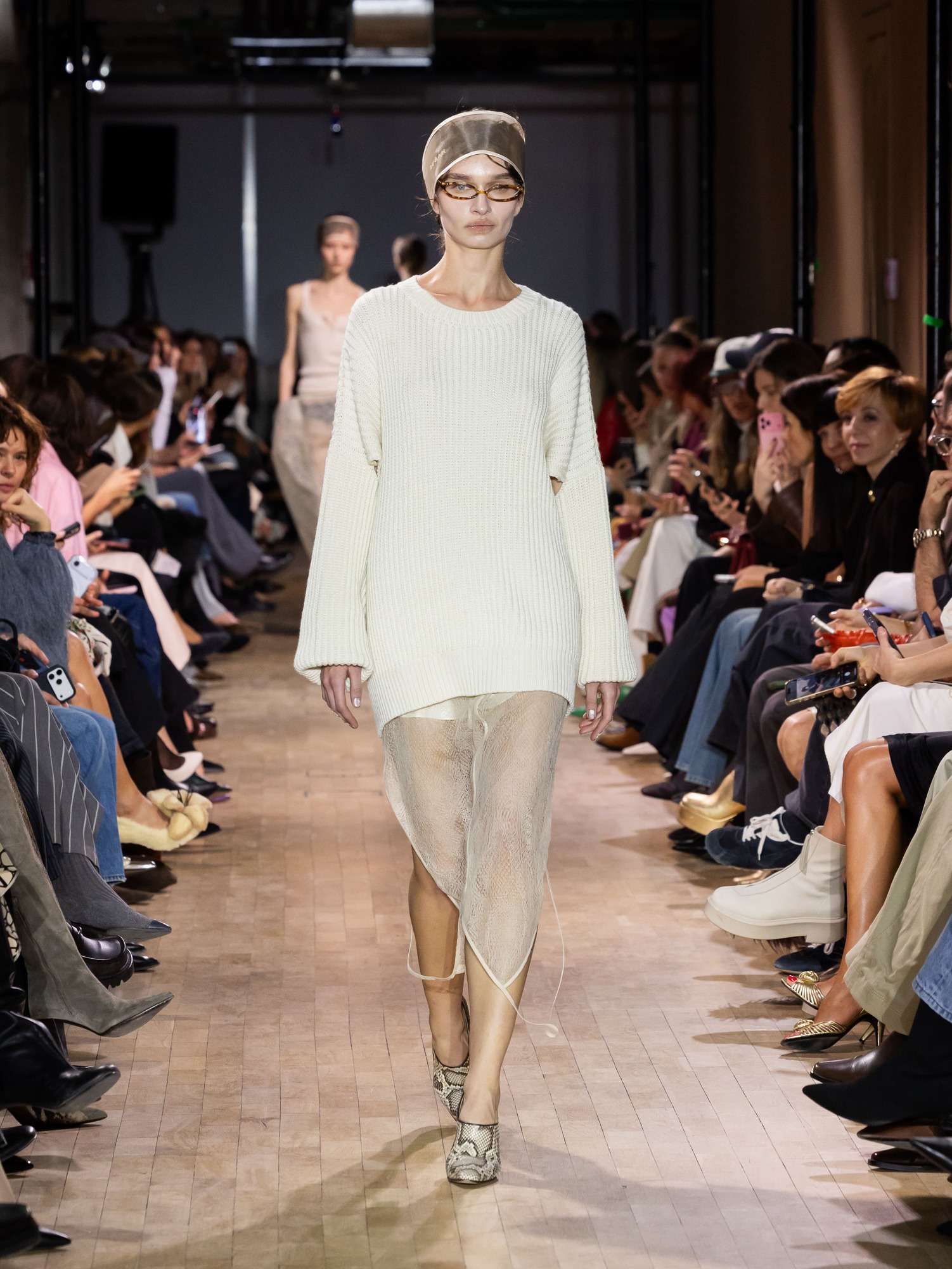 Свитер с крупной вязкой и полупрозрачная юбка, создающие интересный текстурный контраст, завершенный стильными очками