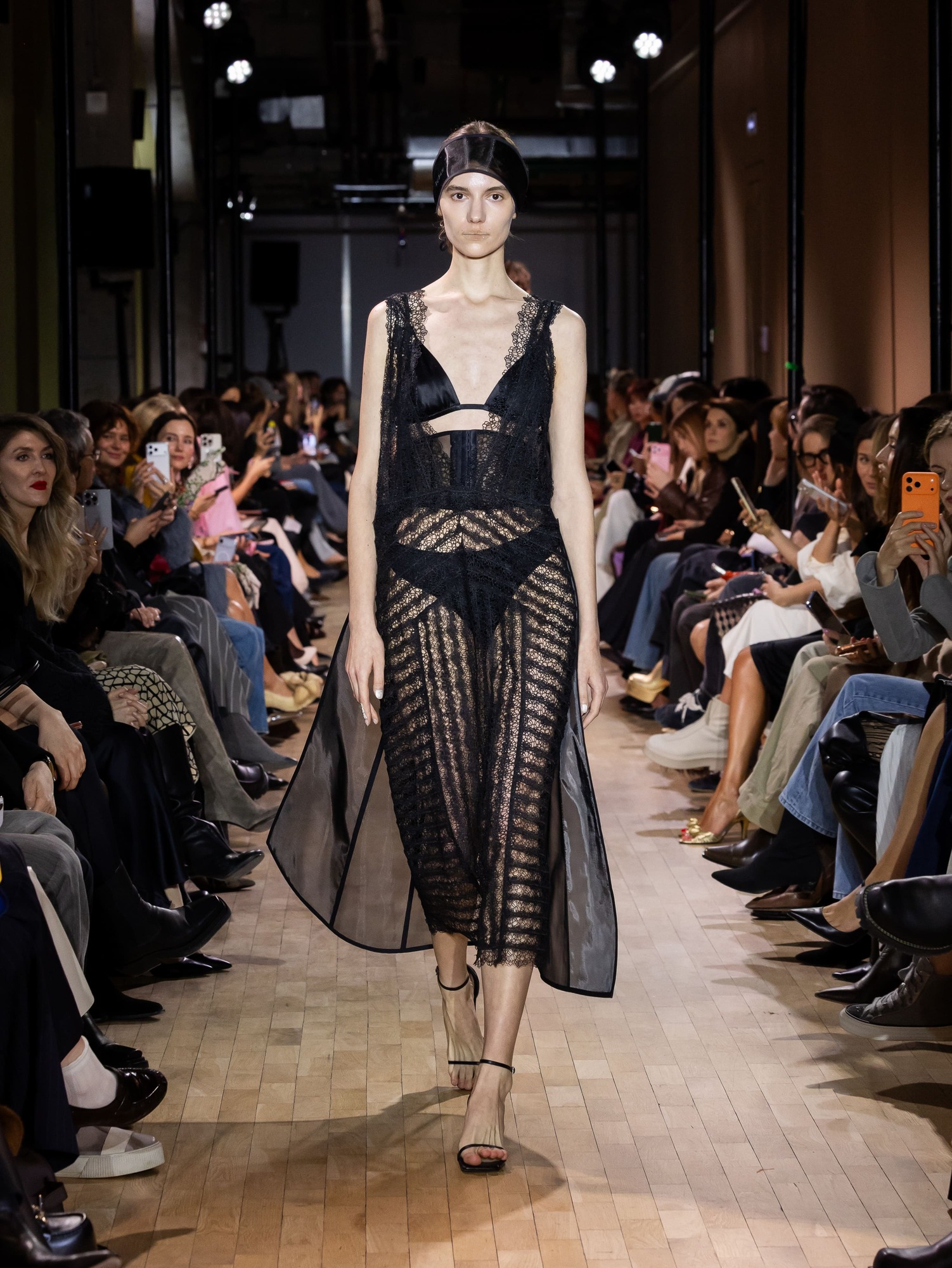 Элегантное черное платье из сетки с кружевными вставками, подчеркивающее силуэт, привлекает внимание зрителей